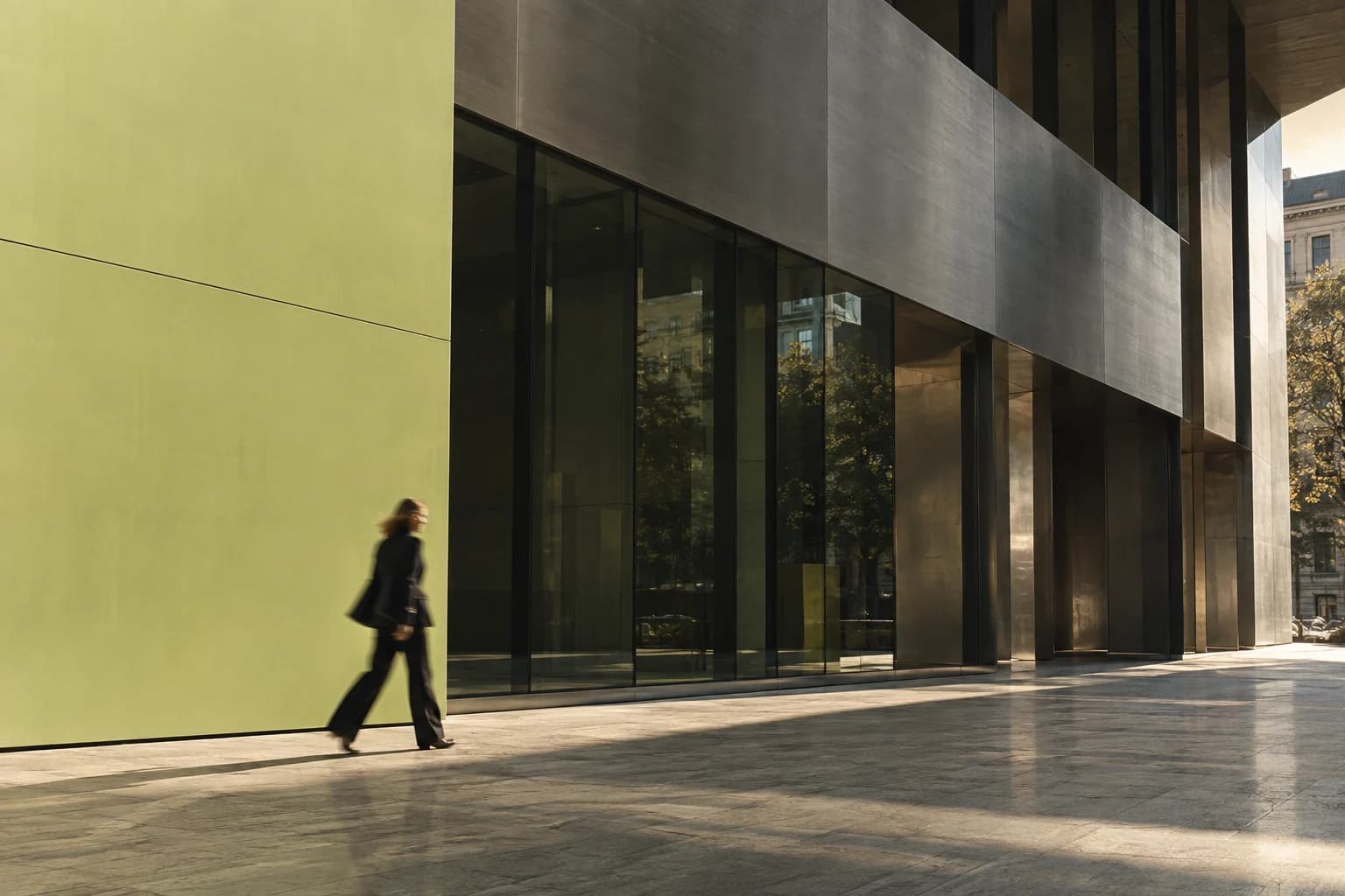 A person walking past a citron panel and a sculptural city facade